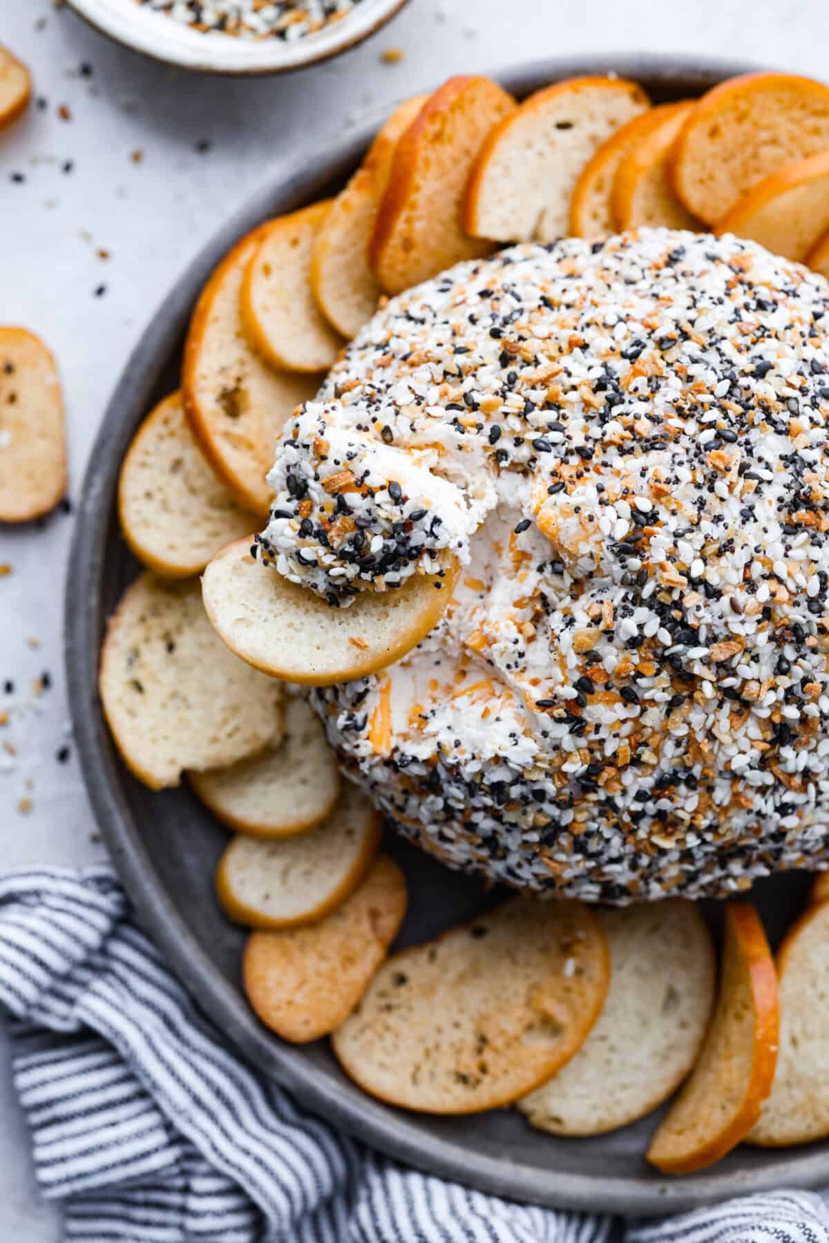 Overhead shot of a crostini taking a scoop out of the cheese ball. 