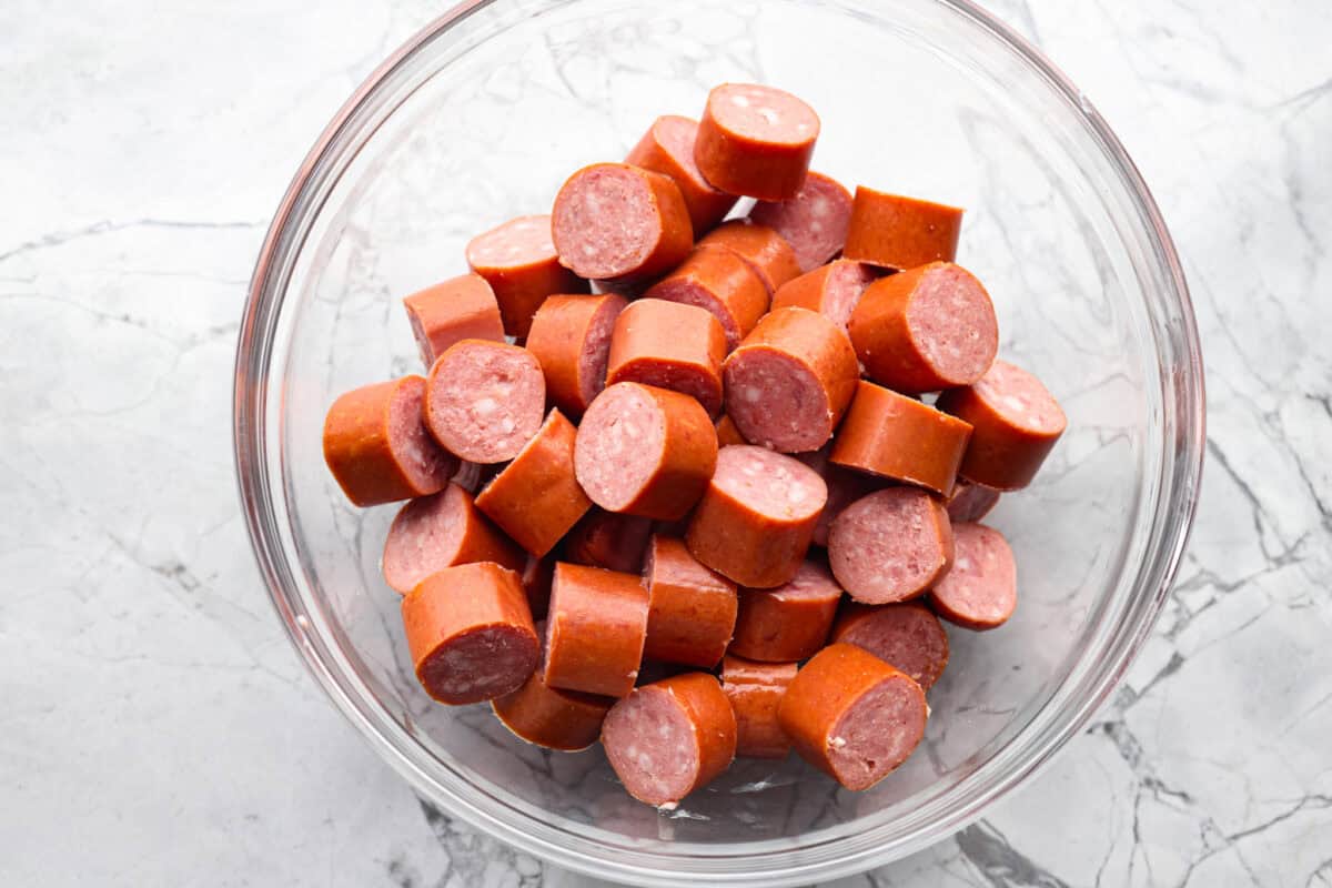 Overhead shot of sliced kielbasa in a bowl. 