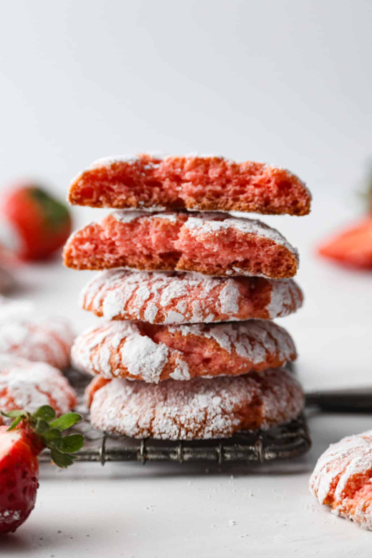 Side shot of stacked strawberry crinkle cookies. 